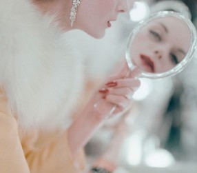 lady looking in hand mirror